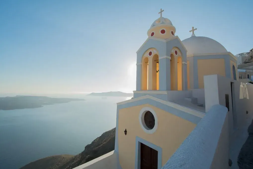 White and yellow church above the sea in hazy light