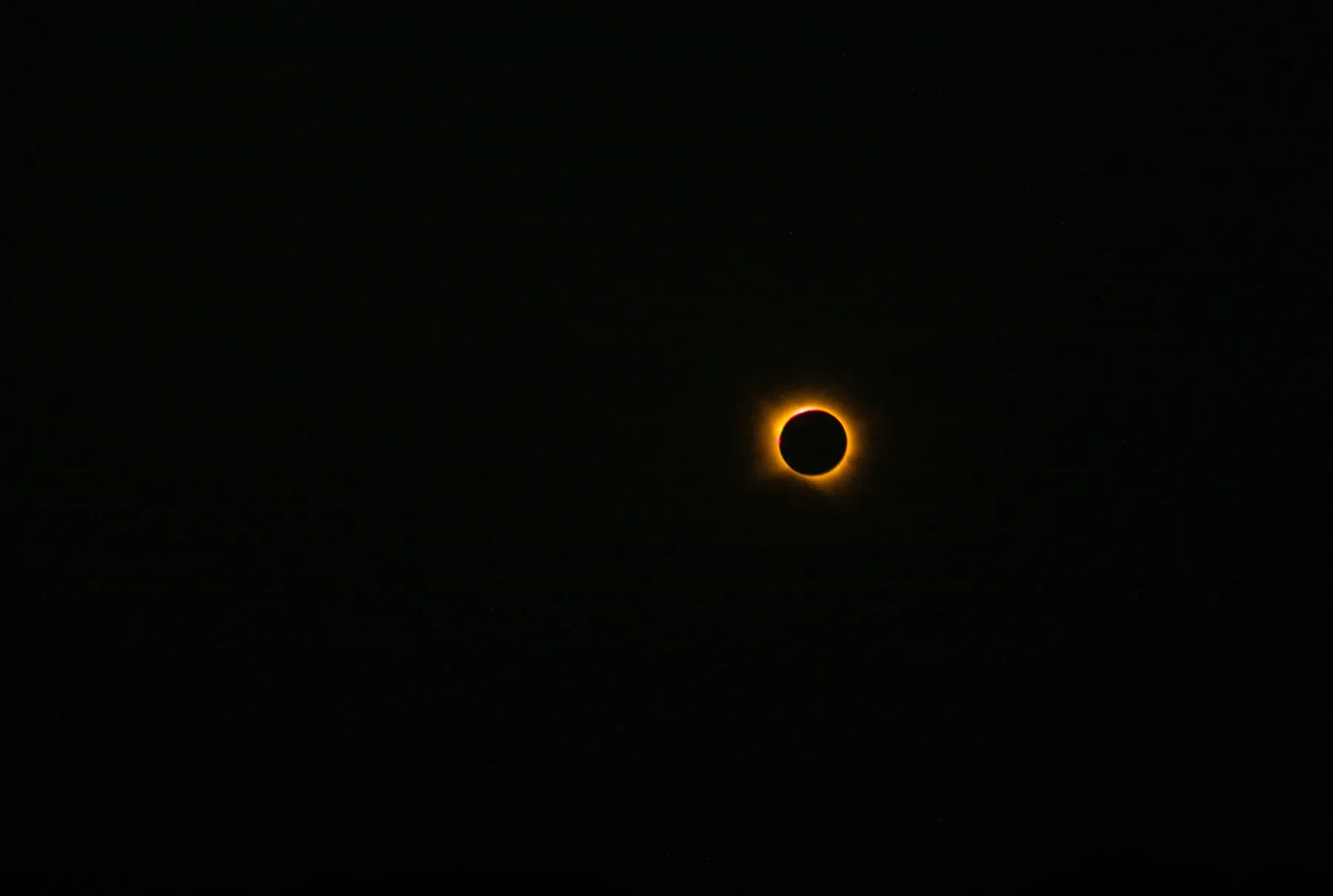 Totale zonsverduistering: de zwarte schijf van de maan met een ring van oranje licht