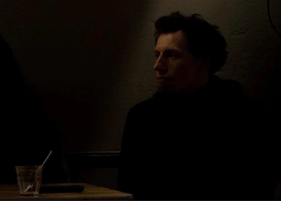 Man in a dark café, lit from the side